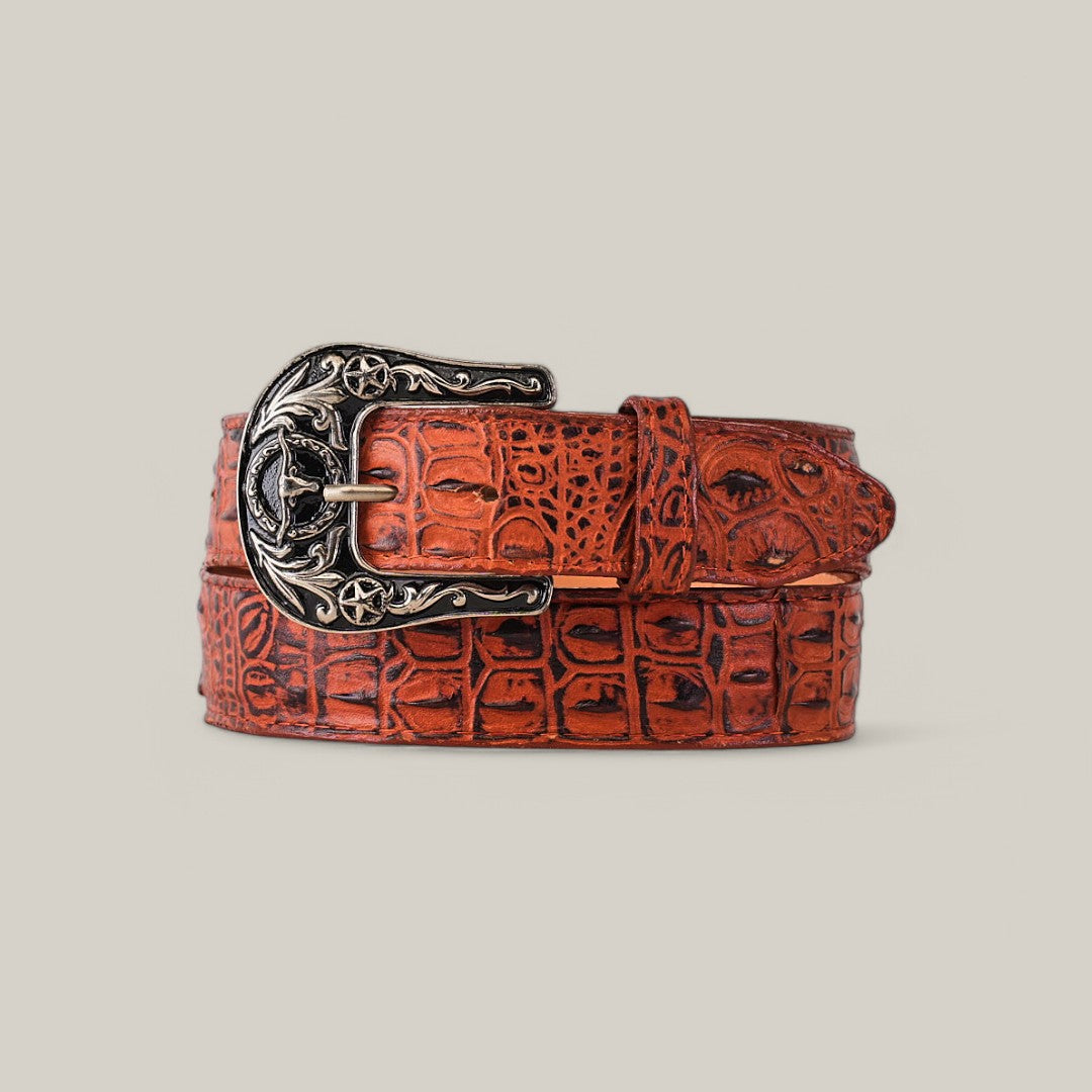 The Caiman Print Cogñac Belt, adorned with a detailed Texas buckle featuring star motifs, is elegantly coiled on a neutral background.