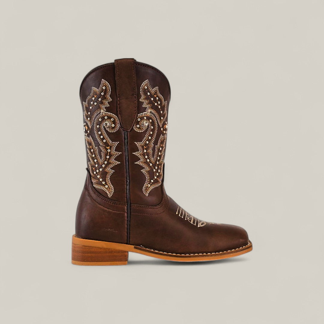 Britany Brown - Square Toe Kids Boots feature a dark brown color, tan and white embroidery, silver studs, and a light wooden heel. Made from durable materials and showcased against a plain beige background.