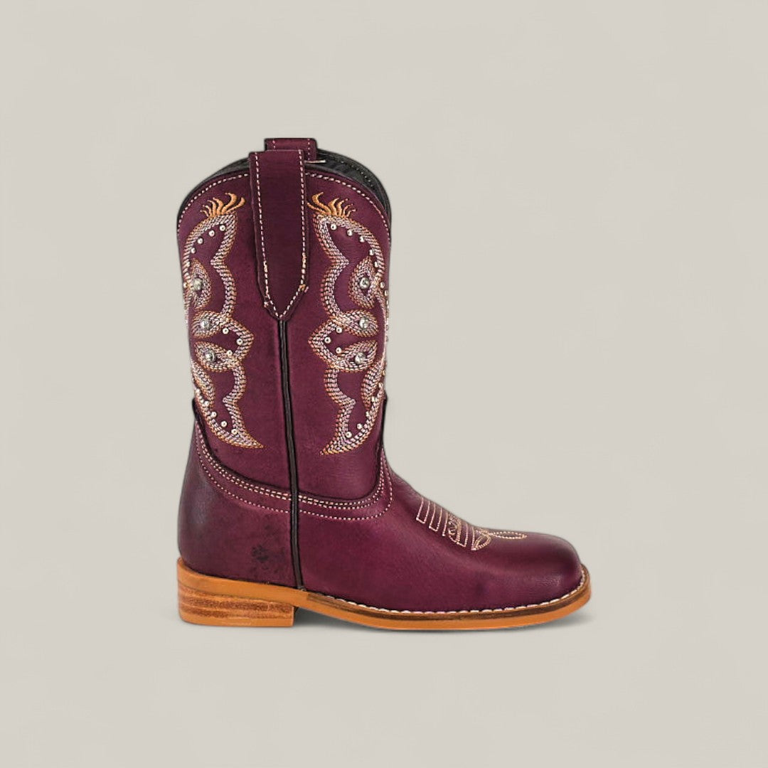 The Blake Purple - Square Toe Kids Boot features maroon leather, beige and gold embroidery, a brown stacked heel, and contrast toe stitching. Displayed in side profile against a plain light background for a trendy look.