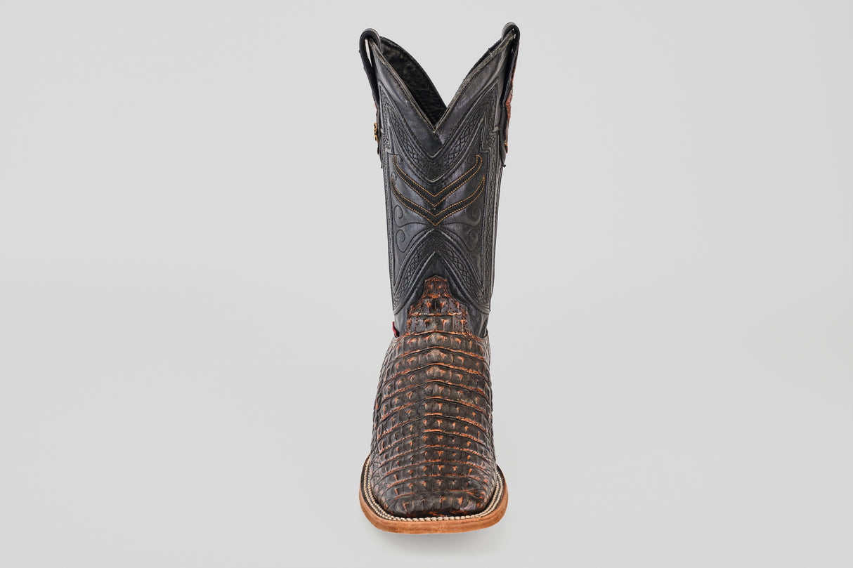 The Exotic Caiman Horn Back - Roma - Square Toe boot features a textured brown caiman-like lower and a black stitched upper shaft, displayed front-facing against a plain light background.