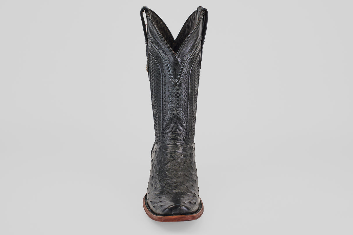 The Exotic Ostrich - Black - Narrow Square Toe boot is shown from the front against a white background, showcasing its textured leather, high shaft, brown sole, and signature narrow square toe design.