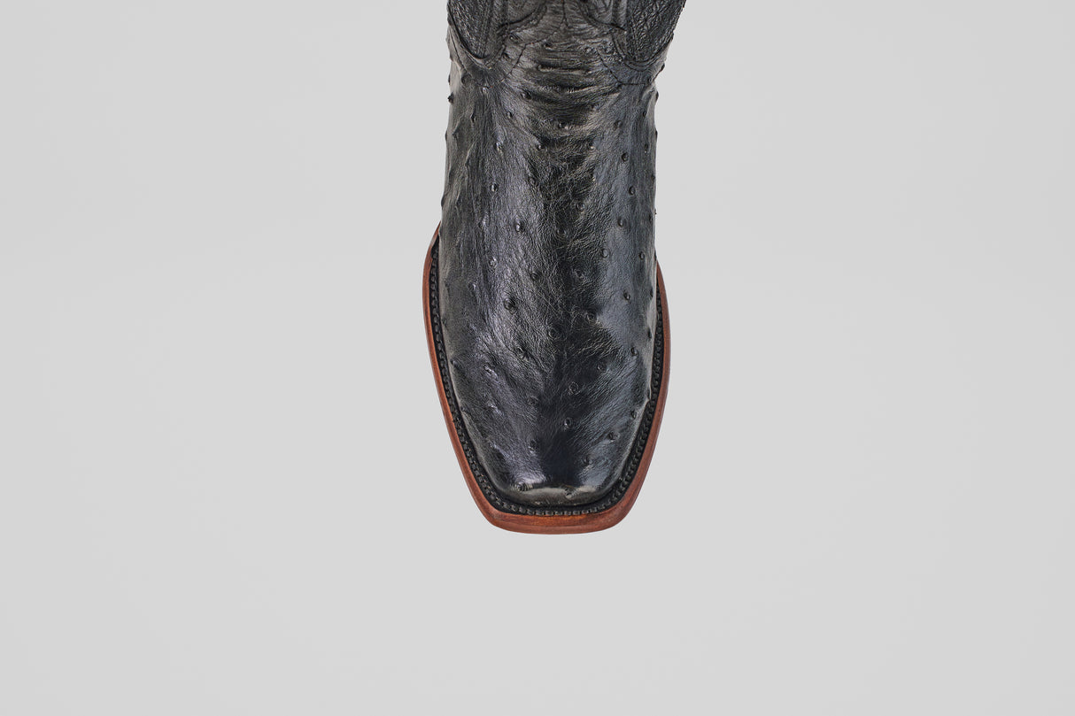 A top-down view of the Exotic Ostrich - Black - Narrow Square Toe boot, featuring a textured leather pattern and brown sole.