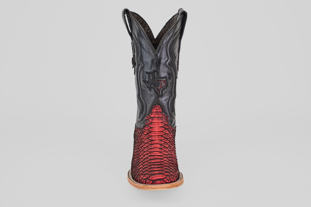 The Tanner – Scarlet – Square Toe is a western cowboy boot with a black upper and red python leather lower, detailed stitching, light brown sole, and square toe, shown from the front against a plain background.