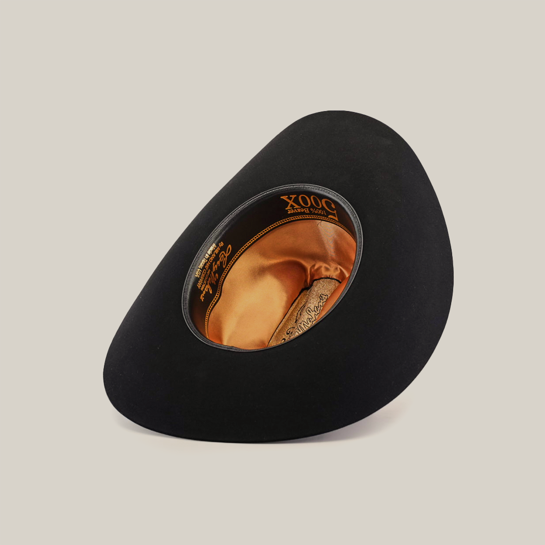 Explore the 500X Superior Black, a premium Western hat. With a black felt design, an asymmetrical curled brim, goldish-orange fabric lining, and XQQQ branding on its decorative band, it offers luxury reminiscent of the Larry Mahan 500x collection.
