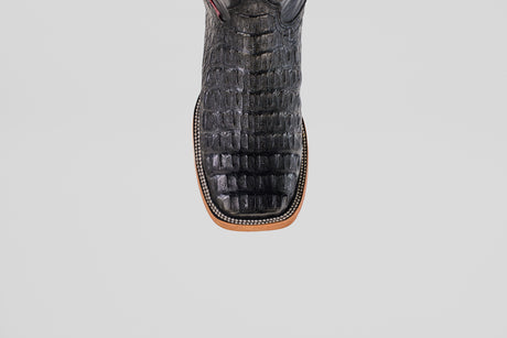 A close-up, top-down view of the Exotic Caiman Horn Back - Black - Square Toe boot highlights its textured reptile-like pattern and decorative welt stitching, showcasing the distinctive style of square toe boots.