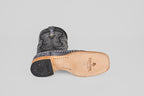 The Austin Leg - Blue Jean - Square Toe men's cowboy boot rests on its side, revealing a light tan leather sole with the Texas Boot Company logo and a black heel, set against a plain light gray background—ideal for blue jeans.