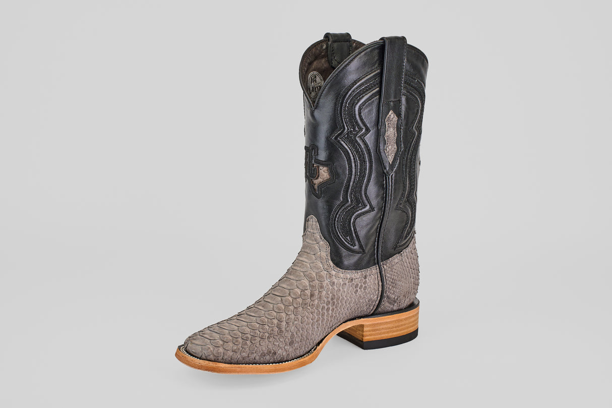 The Tanner - Matte Gray - Square Toe cowboy boot features a textured light gray Python Gris Nobuck snakeskin lower, a decorative black leather upper, and a light tan wooden sole, shown on a plain white background.
