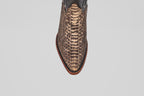 Close-up, top-down view of the Tanner – Rustic Bone – Snip Toe boot, featuring a pointed toe, brown snakeskin-patterned leather, and a reddish-brown sole—these western-inspired boots stand out on a white background.