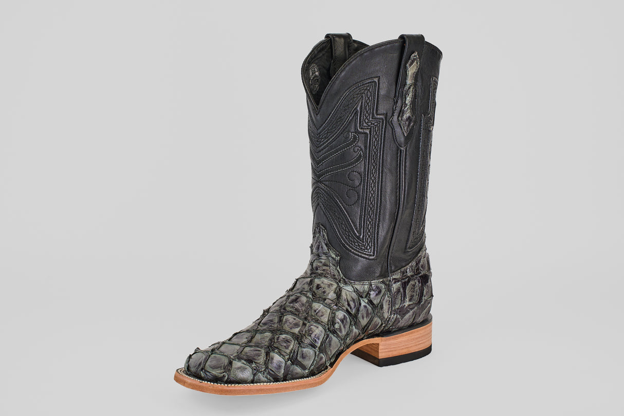 The Conor - Charcoal - Square Toe is a single black cowboy boot with a fish leather-like scaly lower section, detailed stitching on the shaft, a wooden sole, and a slightly pointed toe.