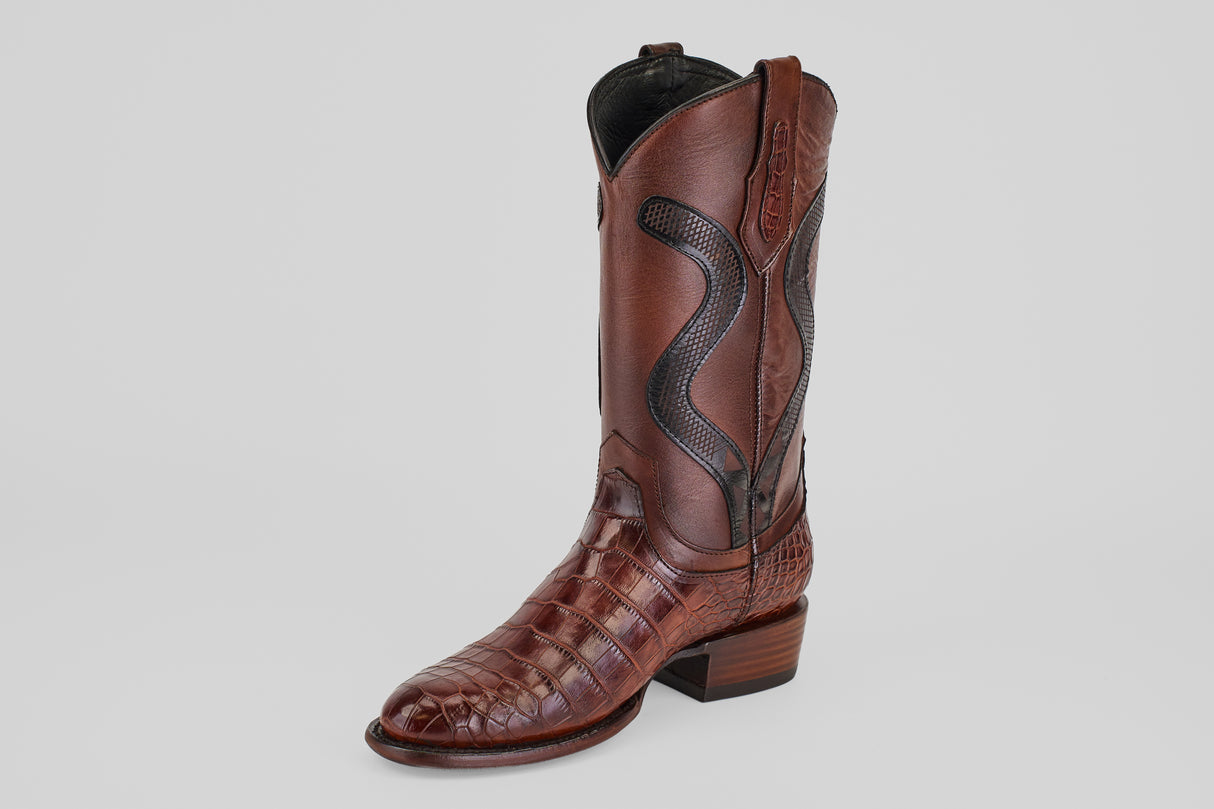 A single James Platimun - Dark Cogñac boot with a roper toe (diamond), featuring textured, crocodile-patterned leather and detailed stitching on the shaft, is shown against a plain light gray background.