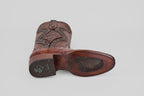 The James Platinum - Dark Cogñac - Roper Toe (Diamond) men’s western boot is shown from the bottom, featuring a brown leather upper, textured sole with branded logo and signature, stitched detailing on heel, and a plain light background.