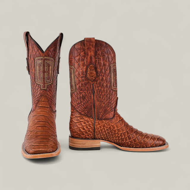 The Python Print Rustic Cogñac - Square Toe boots feature brown leather with a textured python print and embroidered HP initials on the shafts, displayed against a plain light background.