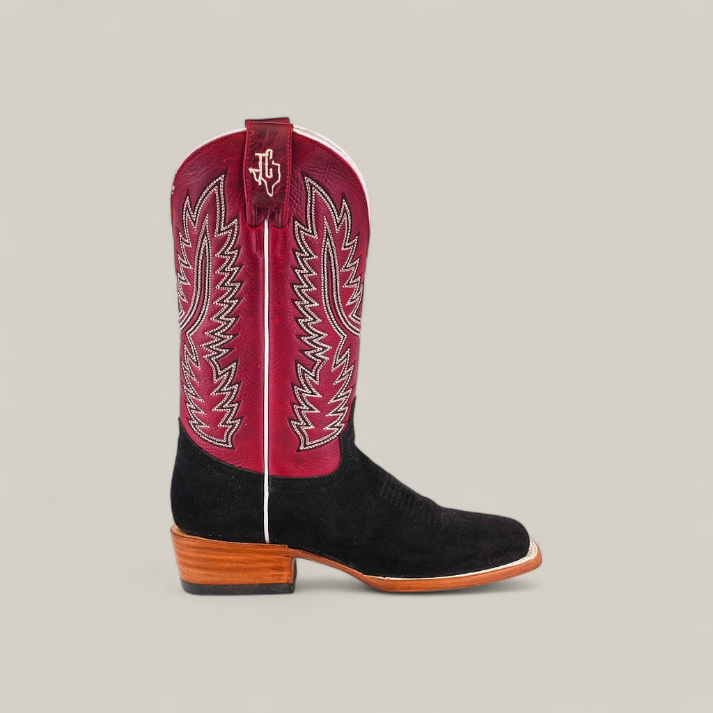The Colt - Black - Square Toe men’s boot features a black suede foot, wooden heel, and tall red shaft with white decorative stitching, displayed on a plain light gray background. This premium piece delivers standout classic style.