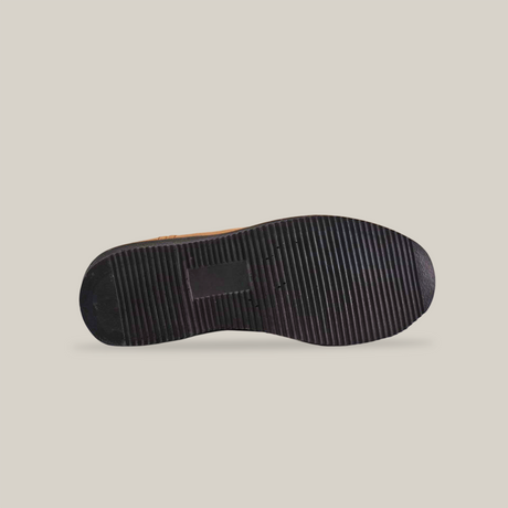 The image showcases the sole of a Tan Roper Laredo Soft Toe boot, featuring a ribbed pattern on its mostly black surface. A rectangular indent near the heel highlights its premium build. The boot stands out against a white background.